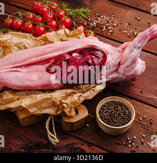 Frisches Kaninchenfleisch, zubereitet für ein Gourmet-Essen in einer rustikalen Küche mit Kräutern und Gewürzen Stockfoto