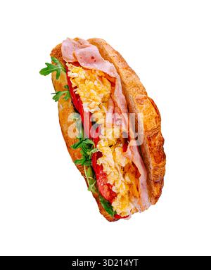 Köstliches Croissant-Sandwich gefüllt mit Schinken, Rührei und frischem Gemüse für ein zufriedenstellendes Frühstück Stockfoto