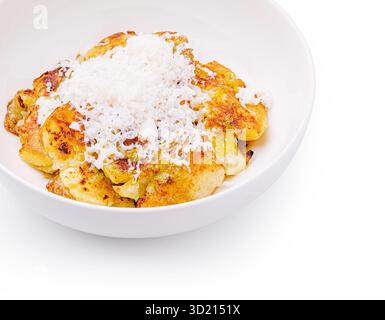 Leckere gebackene Bananen, garniert mit Kokosnuss in einer sauberen Schüssel auf weißem Hintergrund Stockfoto