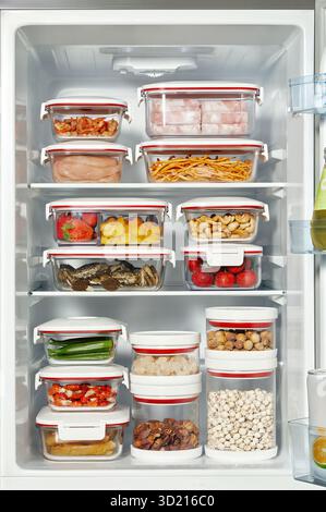 Organisierter Kühlschrank-Innenraum mit Glas-Lebensmittel-Lagerbehälter gefüllt mit Fleisch Obst Gemüse Nüsse Stockbild Stockfoto