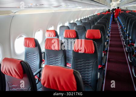 Leerer Innenraum der Kabine des Flugzeugs mit Reihen schwarzer und roter Sitze am Tag vor dem Flug Stockfoto