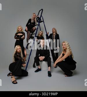 Gruppe von stilvollen Einzelpersonen, die kreativ in zeitgenössischem Studio-Setting posieren Stockfoto