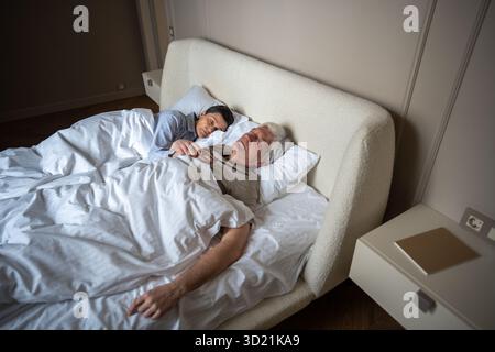 Ein liebevolles älteres Ehepaar, das morgens zusammen im Bett schläft. Vertrauen, emotionale Sicherheit Stockfoto