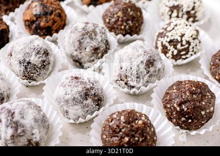 Verschiedene rohe vegane Kugeln Trüffel in Papierbechern Stockfoto