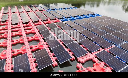Drohnenansicht des schwimmenden Sonnenkollektors. Solar-Photovoltaik-Panel PV-System im Industrie-See-Wasserteich. Energieeinsparung mit Clean Power. Stockfoto