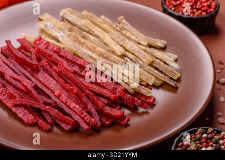 Ein Set Jerky oder Snacks mit Huhn und Fisch mit Salz und Gewürzen Stockfoto