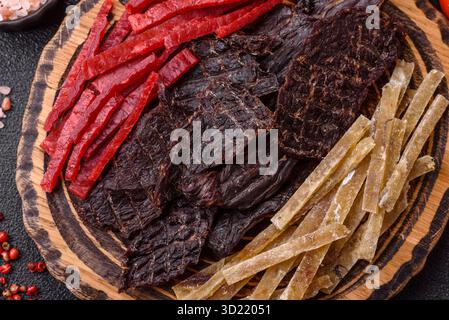 Ein Set Jerky oder Snacks aus Rindfleisch, Huhn und Fisch mit Salz und Gewürzen Stockfoto