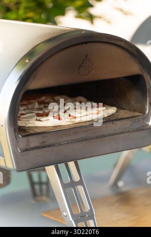 Pizza im Ofen im Freien mit geschmolzenem Käse Stockfoto