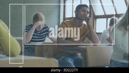 Das Kinn ruht, ein Schüler in ockerem Poloshirt, der direkt im Klassenzimmer der Highschool blickt, mit Schreibtischen Stockfoto
