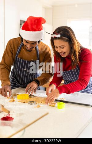 Kombinieren Sie das Rollen und Schneiden von Keksteig mit Keksschneider und Nudelnadel in der Küche Stockfoto