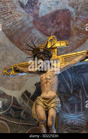 Jesus christus hat auf einem goldenen Kreuz gekreuzigt, mit einer Dornenkrone, die christliches Leiden und Opfer veranschaulicht Stockfoto