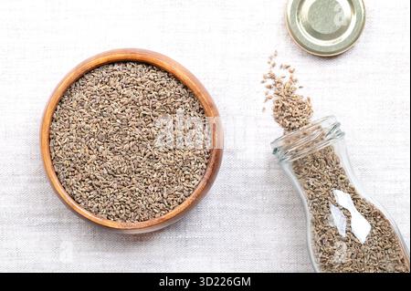 Anis, Anissamen, in einer Holzschale, auf Leinen. Fälschlicherweise Samen, Anisfrüchte, aus der Pflanze Pimpinella anisum genannt, werden verwendet, um Lebensmittel usw. zu aromatisieren Stockfoto