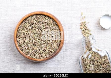 Fenchelsamen, in einer Holzschale, auf Leinen. Fenchelfrüchte werden fälschlicherweise als Samen bezeichnet und als Gewürz verwendet, die beim Kochen verwendet werden, mit anisähnlichem Geschmack. Stockfoto