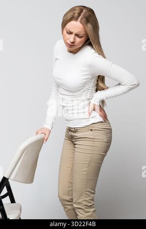 Frau mit Schmerzen, Muskel- oder chronischen Nervenschmerzen im Rücken. Erkrankungen der Wirbelsäule, Skoliose Stockfoto