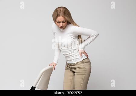 Frau mit Schmerzen, Muskel- oder chronischen Nervenschmerzen im Rücken. Erkrankungen der Wirbelsäule, Skoliose Stockfoto