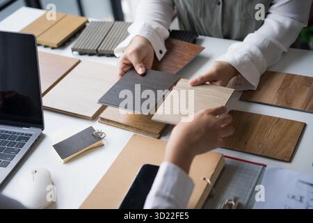 Innenarchitektin präsentiert umweltfreundliche Holzmaterialmuster für nachhaltige Wohnkultur Stockfoto