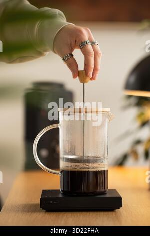 Ein Mann macht Kaffee in einer französischen Presse. Kaffee, Methoden der manuellen Kaffeezubereitung. Stockfoto