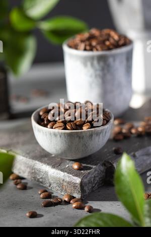 Eine Handvoll gerösteter Kaffeebohnen in Minsk auf grauem Hintergrund. Stockfoto