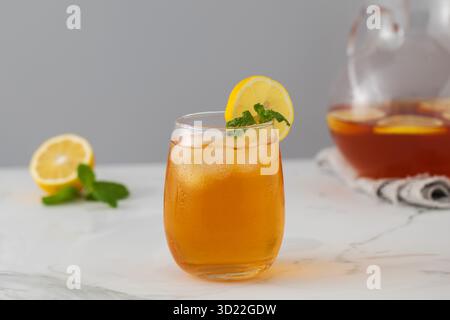Eistee mit Zitrone und Minze in einem Glas und in einer Kanne. Sommergetränke. Stockfoto