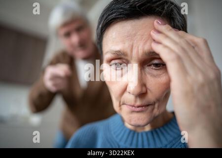 Müde traurige reife Ehefrau bei geistiger Ermüdung durch andauernden grausamen Ehemann in Beziehung Stockfoto