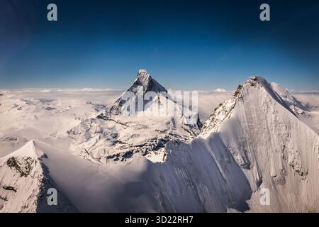Wir gehören wirklich zu den Titanen der Alpen. Wir fahren am Obergabelhorn vorbei. In der Nähe seines Gipfels ein einsamer Kletterer. Das Matterhorn perfektioniert das Bild. Stockfoto