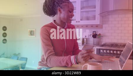 Frau mit Jacke, Kreditkarte und Laptop in der modernen Küche Stockfoto