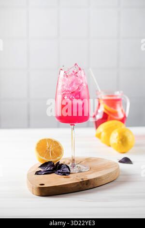 Erfrischende Limonade aus rotem Basilikum und Zitrone in einem Glas und fliegende Spritzer. Ein Sommergetränk. Stockfoto