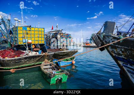 Farbenfrohe Fischerboote legten an einem lebhaften, geschäftigen Hafen unter einem klaren blauen Himmel an. Essaouira, Marokko Stockfoto