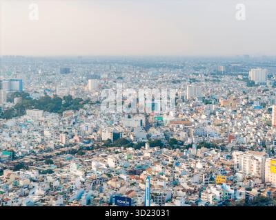 Aus der Vogelperspektive eines weitläufigen, dicht besiedelten Stadtbildes unter einem trüben Himmel. Ho-Chi-Minh-Stadt, Vietnam Stockfoto