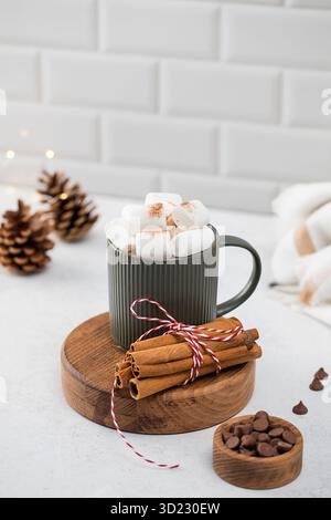 Neujahrskakaobecher mit Marshmallows und Zimt auf Rundbrett Stockfoto