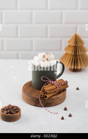 Neujahrskakaobecher mit Marshmallows und Zimt auf Rundbrett Stockfoto