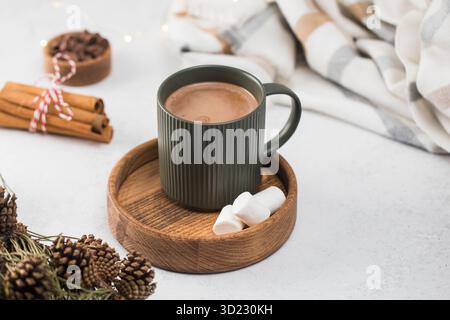 Heiße Schokoladentasse und kleine Marshmallows auf Holzuntertasse Stockfoto