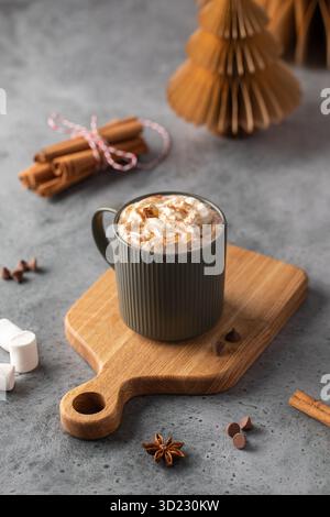 Eine gemütliche Tasse Kakao mit Schlagsahne, garniert mit Zimt. Das Konzept von Neujahr und Weihnachten Stockfoto