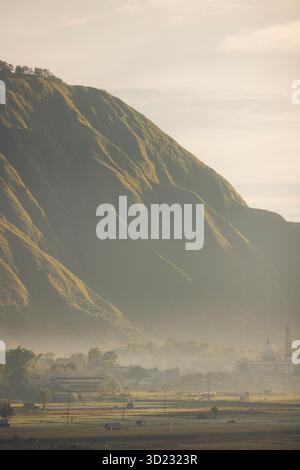 Neblige Berglandschaft mit üppigem Grün unter einem ruhigen, bedeckten Himmel. Lombok, Senaru, Indonesien Stockfoto