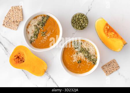 Teller mit Kürbissuppenpüree, Kürbis und Sesamsamen. Herbstmenü. Stockfoto