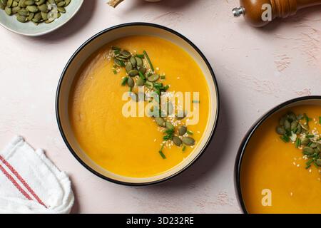 Köstliche Kürbissuppe im Herbst, garniert mit Samen und Schnittlauch für gemütlichen Komfort. Herbstmenü. Stockfoto