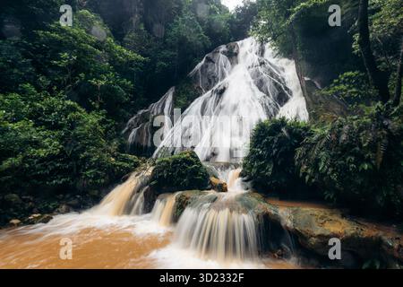 Üppig grüner Wasserfall, der über Felsen stürzt und von tropischem Wald umgeben ist. Ambon, Maluku, Indonesien Stockfoto