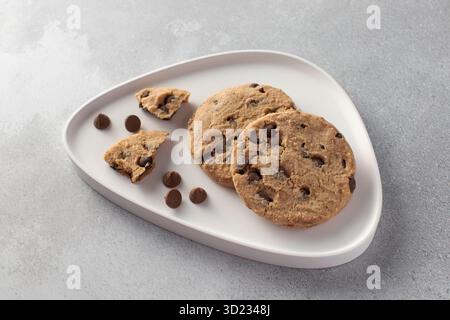 Schokoladenkekse auf einem modernen Teller mit grauem Hintergrund. Stockfoto