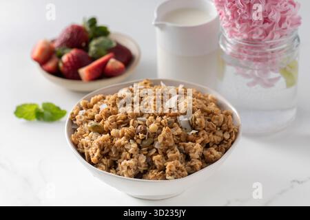 Knuspriges hausgemachtes Müsli mit Mandelscheiben in einer Schüssel mit Erdbeeren. Gesunde Ernährung Stockfoto