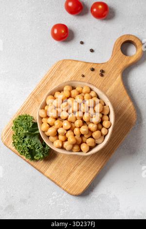 Kichererbsen in Dosen in Schüssel auf Holzbrett für vegetarische Speisen. Gesunde Ernährung Stockfoto