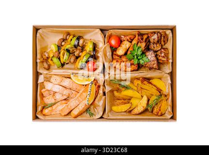 Eine ausgewogene Catering-Box, die in vier Bereiche unterteilt ist und gegrillte Lachsfilets mit Zitrone, geröstetes Gemüse (zucchi Stockfoto