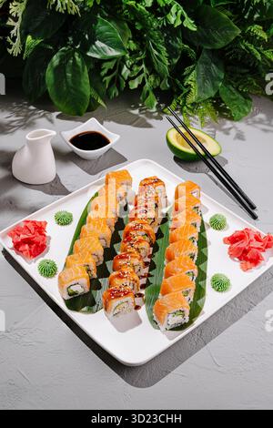 Sushi-Platte mit verschiedenen Arten von Brötchen mit Beilagen und Saucen Stockfoto
