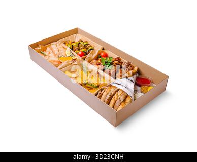 Köstliche Auswahl an gegrilltem Fleisch, Gemüse und Beilagen in einer Take-Out-Box Stockfoto