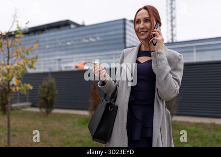 Geschäftsfrau, die außerhalb des Büros telefoniert Stockfoto