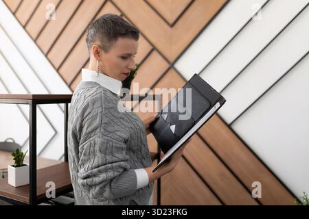 Geschäftsfrau untersucht Dokumente Ledermappen im Büro Stockfoto