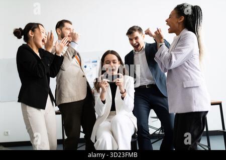 Multirassische junge Kollegen, die an kreativen Gruppenmeetings beteiligt sind, motivierende Briefings durchführen oder Vorträge halten Stockfoto
