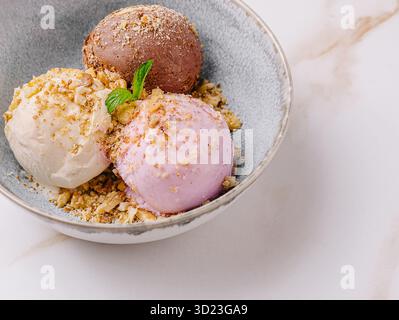 Verschiedene Eissorten in einer Schüssel mit Belag serviert Stockfoto