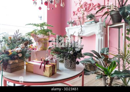 Weihnachtskompositionen aus Naturtanne und Geschenkschachteln sowie mit Weihnachtsgeschenken in stilvollem Pink Stockfoto