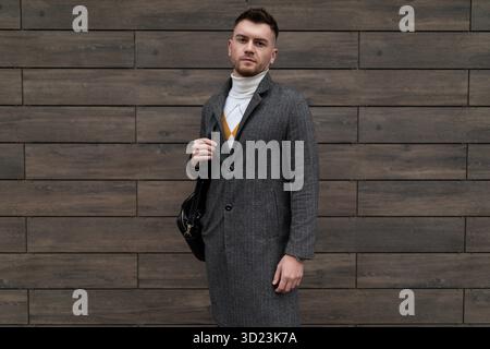 Porträt eines erfolgreichen jungen Geschäftsmannes in Geschäftskleidung mit Handy in der Hand in Brille zum Sehen Stockfoto