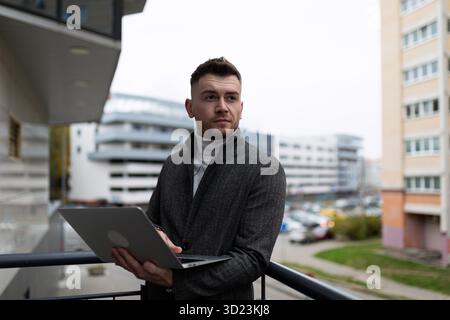 Geschäftsmann, der außerhalb des Büros am Laptop arbeitet Stockfoto